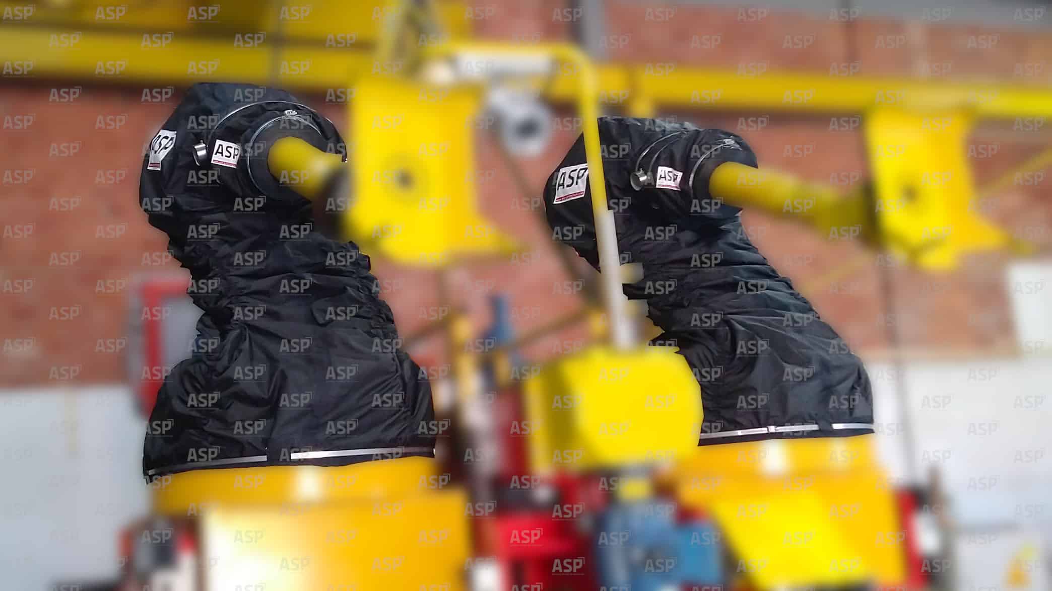 C'est une photo qui présentent deux robot industriels de la marque fanuc, tout jaune, qui sont protéger par deux housses ATEX noire dans les milieux explosif